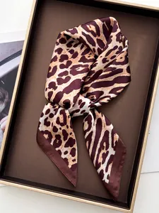 Detailed close-up of leopard print satin scarf texture with elegant glossy finish