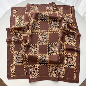 Détail de foulard carré en soie avec chaînes dorées et imprimé léopard classique