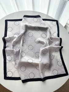 Detail of elegant square silk scarf with grey and black geometric concentric rings