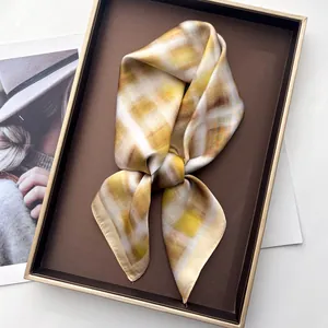 Detailopname van een gele zijden sjaal in geschenkdoos met tijdschrift achtergrond