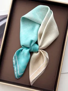 Detail of blue and beige polka dot silk scarf with smooth texture on a display tray
