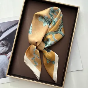 Detailed view of an almond blossom silk scarf elegantly tied in a luxury gift box