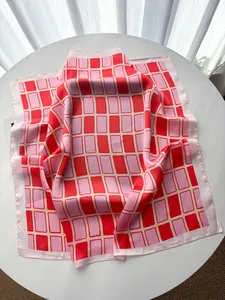 Detailansicht von rosa und roten Gittermustern auf einem weichen Seidenimitat-Halstuch