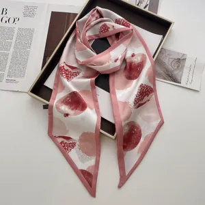 Dettaglio del foulard in seta con stampa di melograno rosa e beige dalla finitura satinata