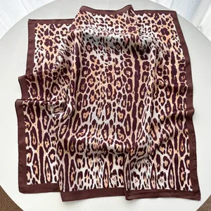 Detailed view of the smooth leopard print silk satin scarf with dark brown bordered edges