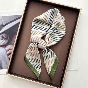 Elegante pañuelo de seda con ondas verdes en caja de regalo y revista de moda