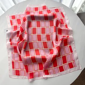 Nahaufnahme des geometrisch karierten Seidenschals in Rot und Rosa mit Satin-Glanz-Struktur