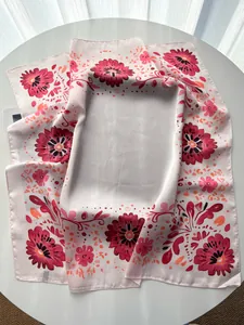 Detail of elegant floral silk scarf with pink base and orange hand-painted flowers