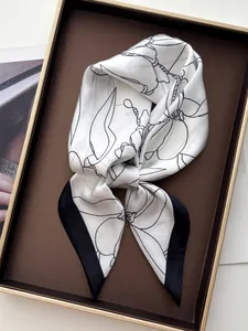 Detail showing vintage magnolia print silk scarf with black border on a tray