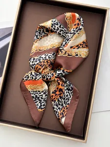 Détail macro du foulard carré en soie avec motif léopard et chaînes dorées