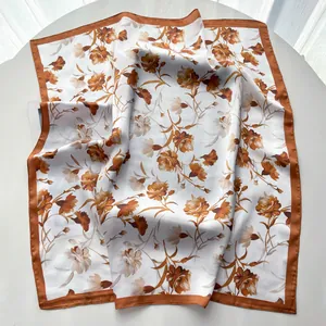 Detailed view of large square silk scarf featuring vintage floral print and satin borders