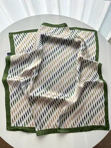 Detalle del estampado geométrico ondulado y costura fina en el pañuelo de seda suave