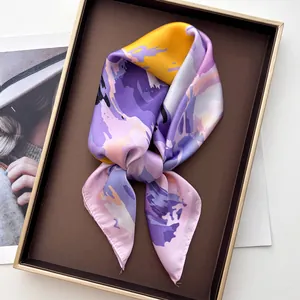 Close-up of abstract floral silk scarf with vibrant colorful prints in a luxury gift box