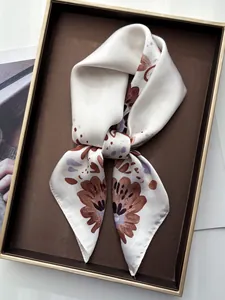 Detail of floral silk scarf in a premium brown gift box with golden accents