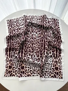 Detail of leopard print silk scarf with wide white satin border and smooth glossy texture