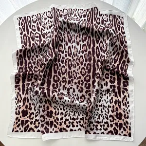 Detailed view of the leopard print silk square scarf showing fabric texture and satin edges
