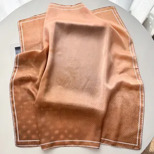 Detail of silk-like square scarf featuring gradient orange and brown polka dot patterns