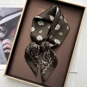 Detail of vintage paisley silk scarf in dark coffee brown on an elegant display tray