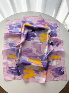 Detail of artistic floral pattern on pink silk square scarf with fine edge stitching