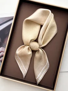 Detailed macro view of beige polka dot silk scarf with elegant white stripes on the end