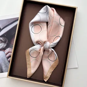 Elegant geometric print silk square scarf in pink and gold, presented in a gift box