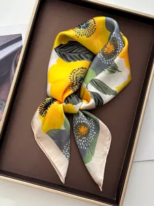 Detail van zijden sjaal met gele papaverprint en satijnachtige textuur op dienblad