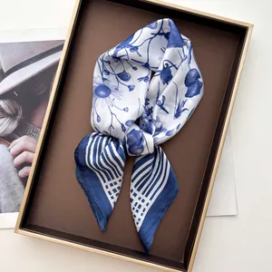 Macro view of the delicate blue floral print and striped edge on a silk-like square scarf