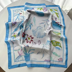 Macro detail of sky blue silk scarf with floral and botanical prints on a white base
