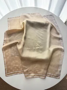 Close-up of a gradient brown polka dot silk scarf with light sheen and white border