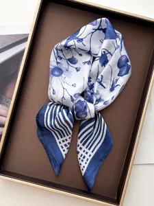 Close-up of knotted blue floral silk scarf with striped borders on a tray