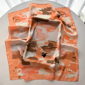 Detail of the abstract floral print and smooth texture on the large square silk scarf
