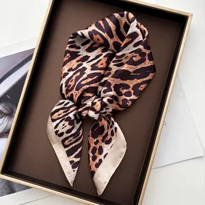 Macro view of luxurious leopard print silk scarf with smooth texture in display tray