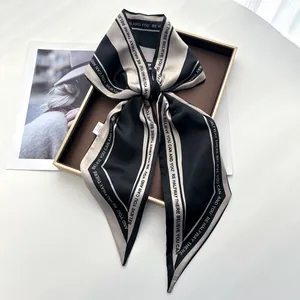 Gros plan détaillé d'un foulard en satin à rayures noires et blanches avec texte