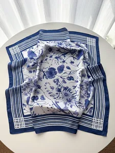 Macro detail of French striped square silk scarf with blue floral prints and smooth texture