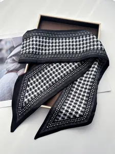 Détail macro d'une écharpe en soie pied-de-poule sur boîte de présentation chic