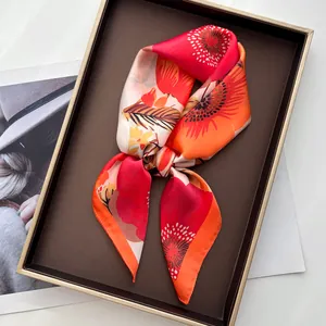 Detail van zijden sjaal met klaproos bloemenprint in geschenkdoos met gouden rand