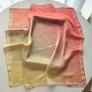 Detail of silk square scarf featuring pink to yellow gradient and delicate polka dots