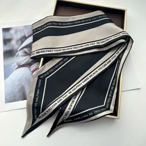 Détail d'un foulard en soie bicolore avec texte de motivation et texture satinée