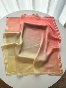 Detailed view of the gradient red and beige square silk scarf with elegant polka dot patterns