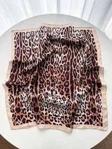 Macro detail of silk-like leopard print square scarf with elegant satin border finish