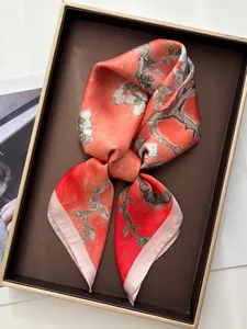 Detailed view of luxury silk scarf with plum blossoms in orange and pink hues