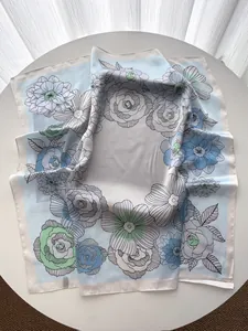 Détail d'un foulard en soie imprimé de fleurs, roses dessinées et bleu clair
