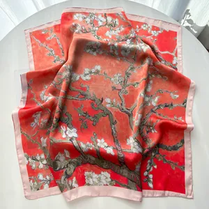 Detail of red silk scarf with white almond blossom print showing glossy satin texture