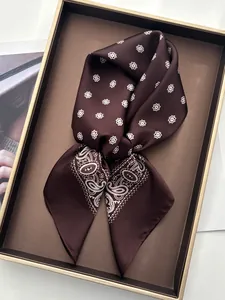 Detail of dark brown silk scarf with white paisley patterns on a golden display tray