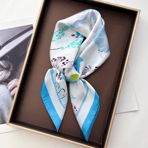 Silk floral shell print square scarf displayed elegantly on a gold-rimmed brown tray