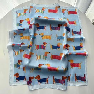 Dettaglio ravvicinato di un foulard in seta azzurro con stampe di bassotti colorati