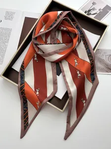 Detail of horse print silk scarf with leopard patterns in orange and ivory on tray