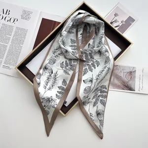 Detailed shot of white satin scarf with black floral prints and deep brown border