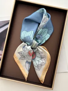 Détail d'un foulard en soie à imprimé floral avec bordures bleu clair et jaune
