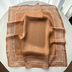 Close-up of caramel paisley silk scarf showing satin texture and geometric patterns